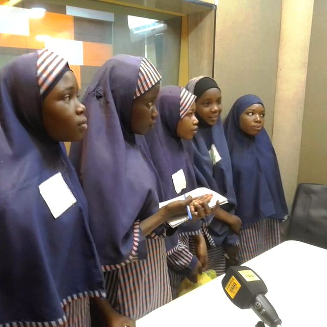 Pupils of the school on a visit to a radio station, standing beside a studio microphone
